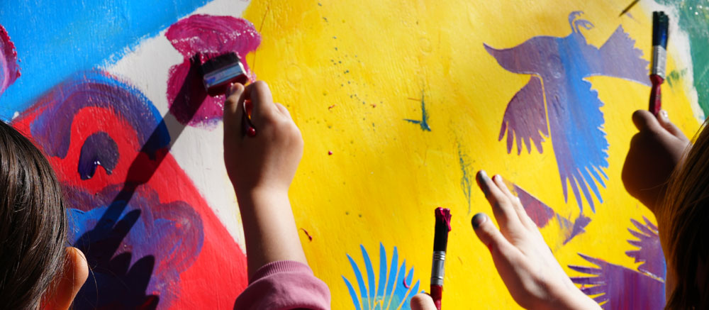 Picture of people painting a colourful mural.