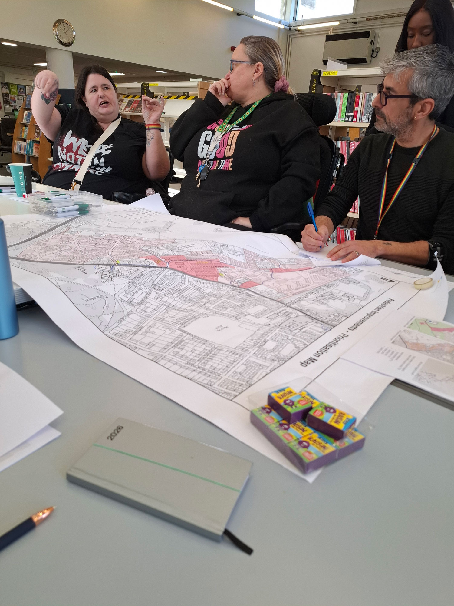 An image showing a large estate plan, which is spread out across a table. People sitting around the table are having a discussion.