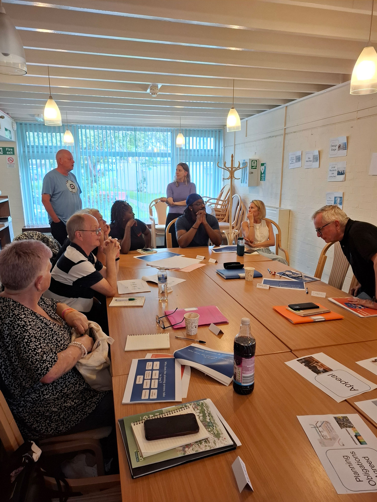 Members of the Alton Community Panel are pictured sitting around a table, having a discussion.