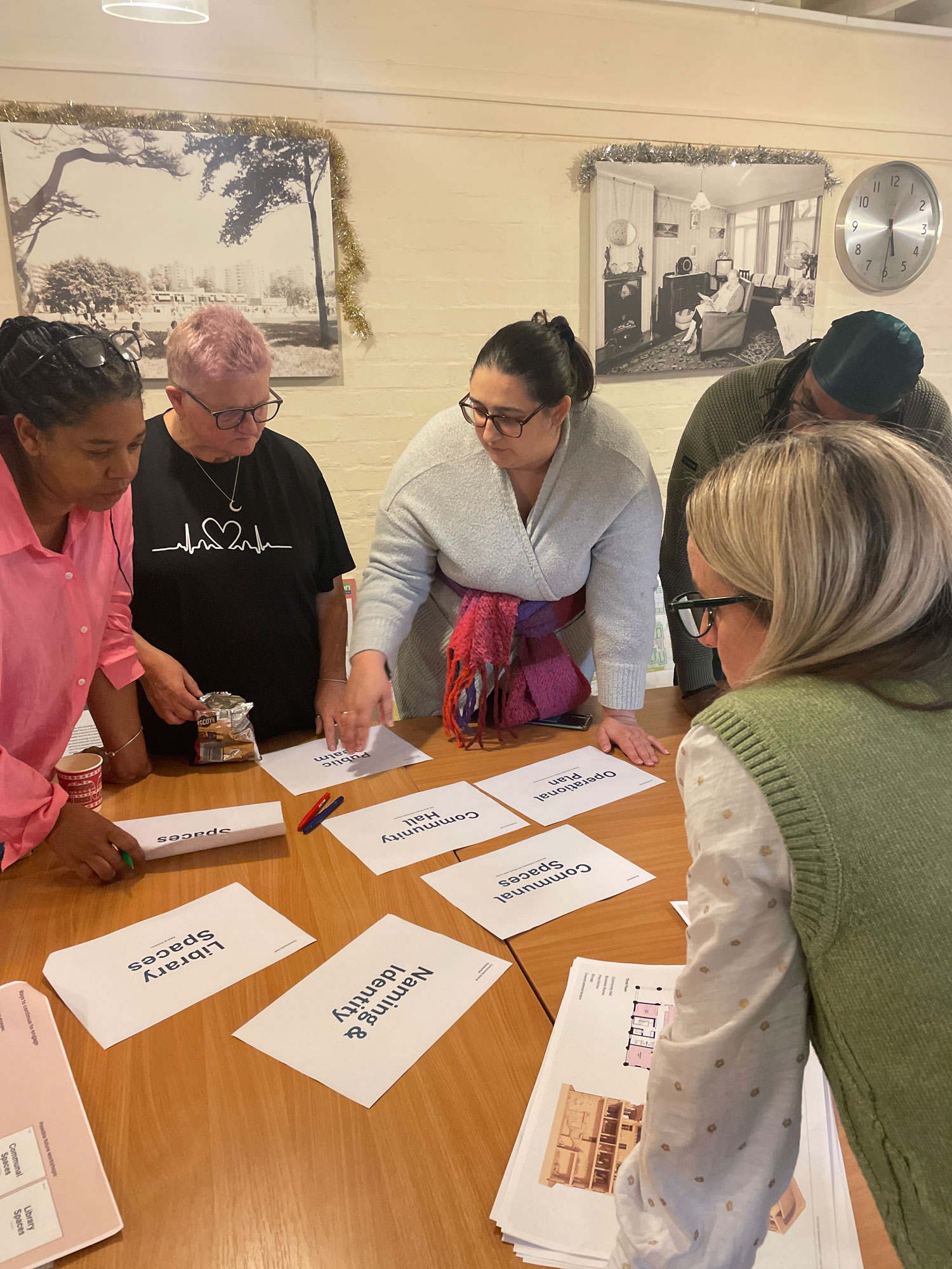Members of the Alton Community Panel are pictured standing around a table, looking at different topics for discussion relating to the new community hub