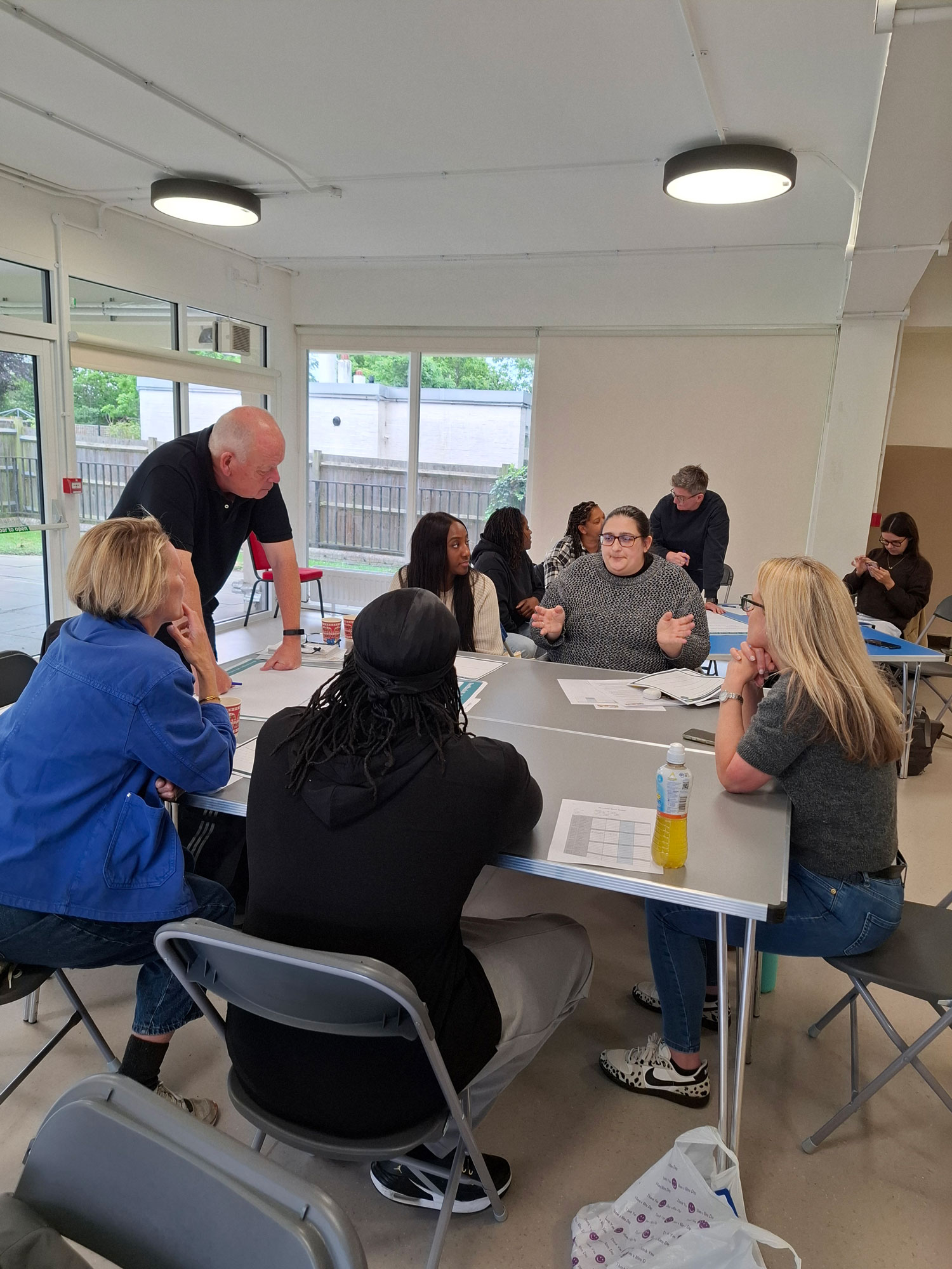 People are pictured sitting around a table having a discussion.