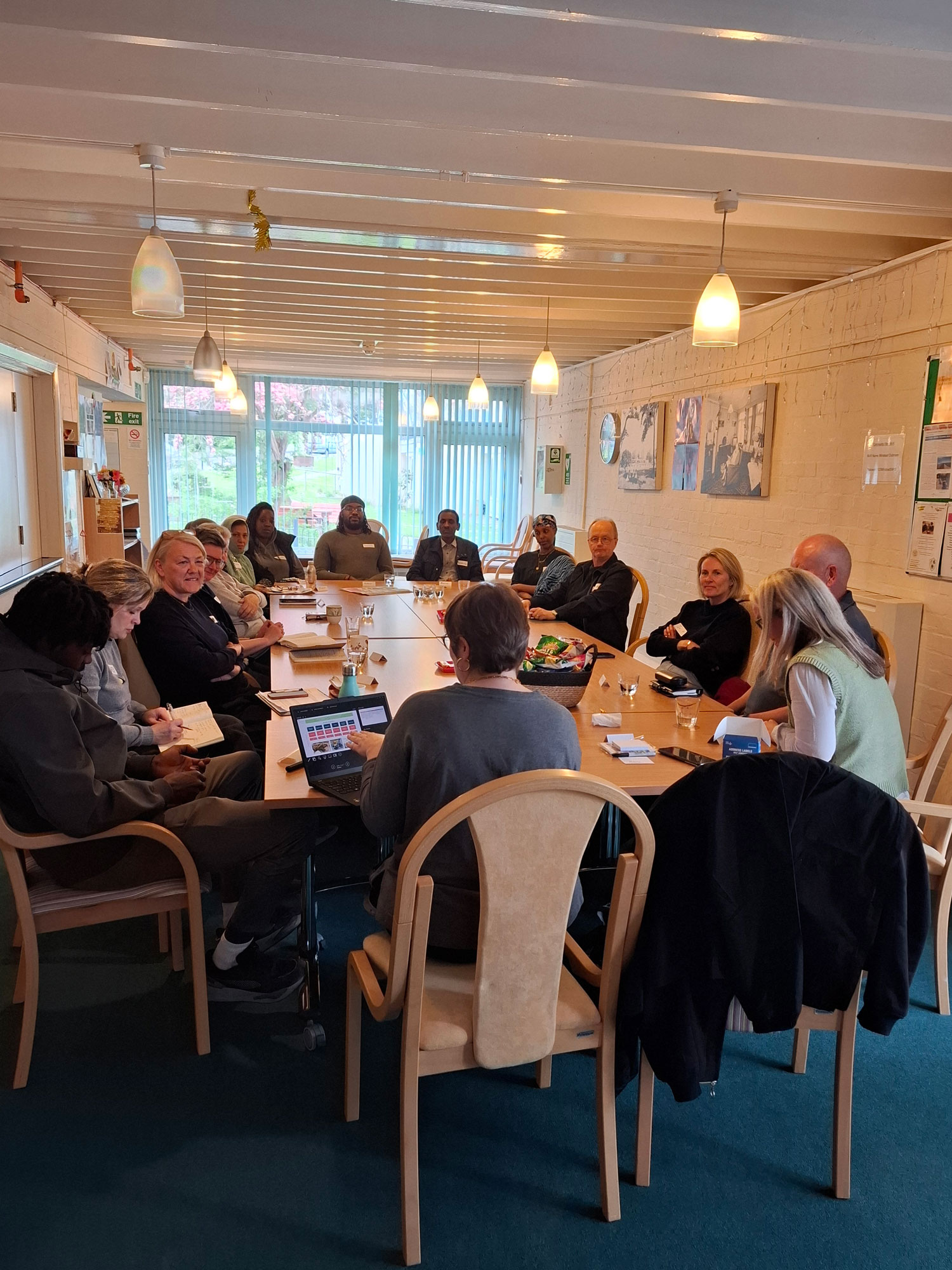 The inaugural meeting of the Alton Community Panel. A group of people are pictured sitting around a large table.