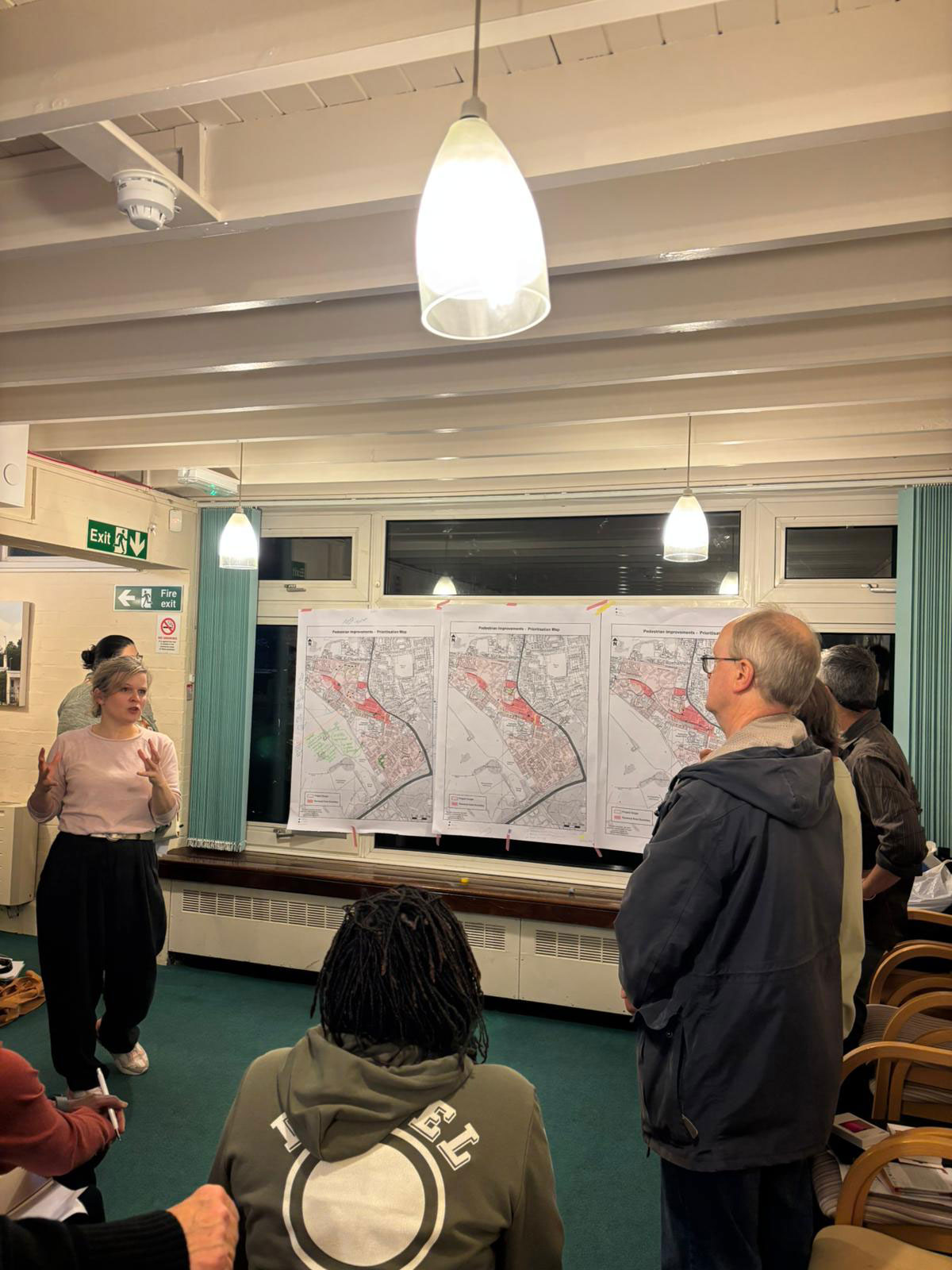 One of the transport planners is pictured standing in front of three similar plans of the estate, explaining something to a group of panel members.