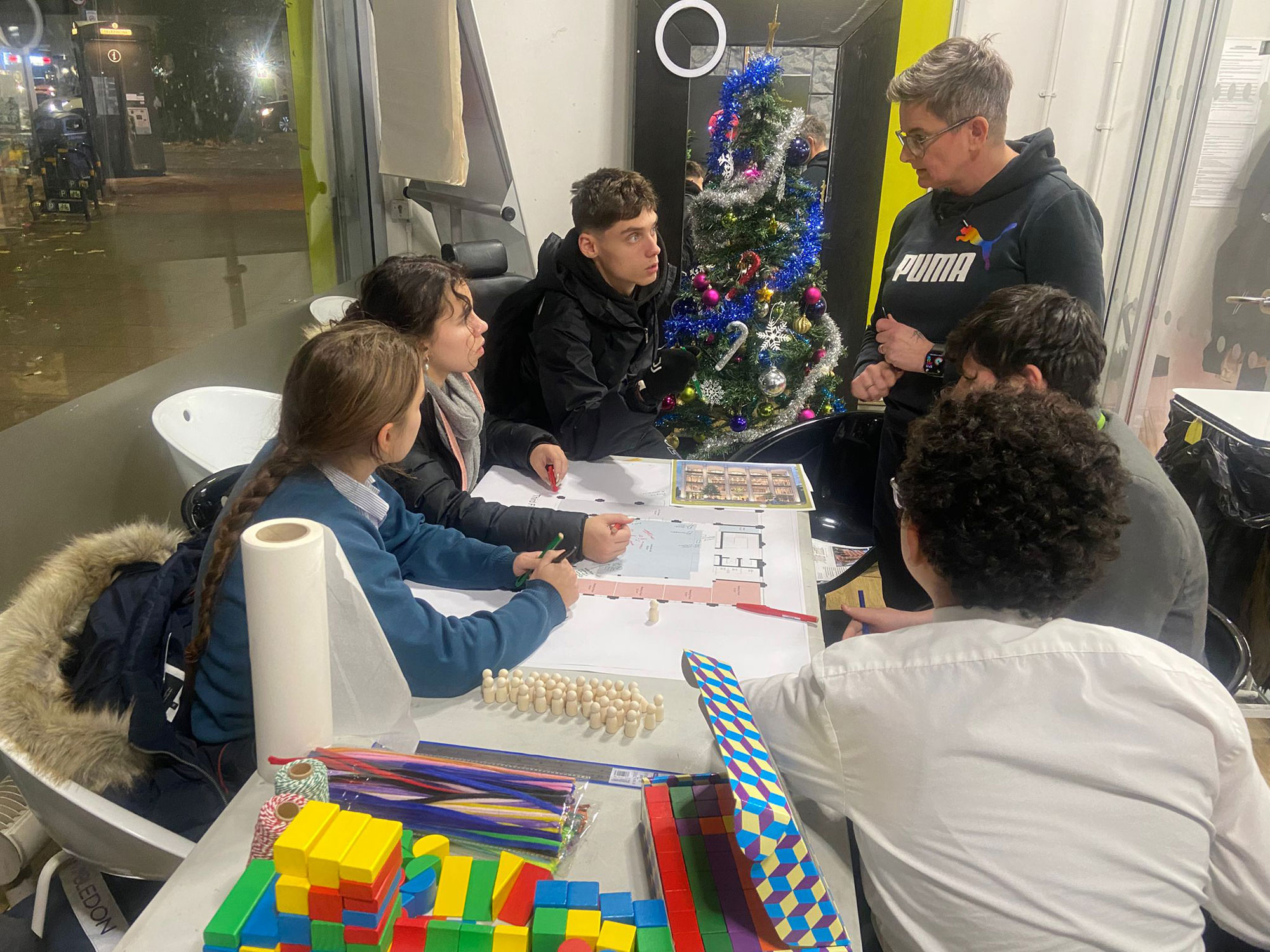 Members of the Youth Advisory Panel are pictured here, sitting around a table, reviewing plans for the new community building
